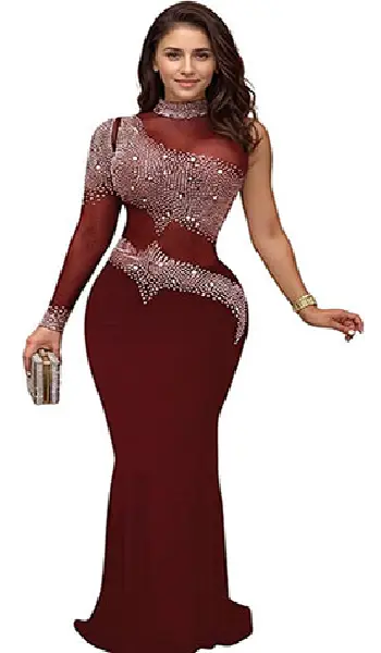 Woman wearing a burgundy one-shoulder long evening dress featuring a sheer mesh bodice heavily embellished with hot drill rhinestones and a fitted floor-length skirt.