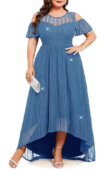 A model wearing a blue plus-size formal dress with a cold-shoulder neckline, short ruffle sleeves, and a high-low hemline, crafted from a sparkly, ribbed-knit fabric with silver threads.