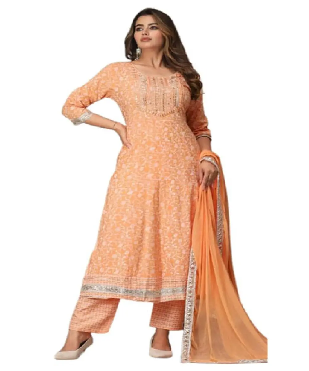 A woman wearing a bright red Anarkali-style kurta with gold-tone floral prints, paired with matching pants and a decorative dupatta.