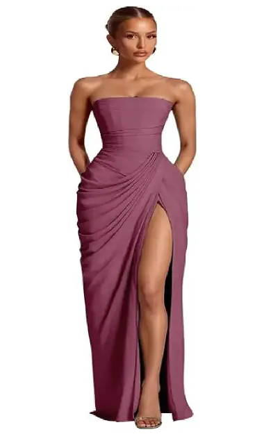 A model wearing a mauve strapless floor-length chiffon formal dress featuring a ruched bodice, side drape, and a high leg slit.