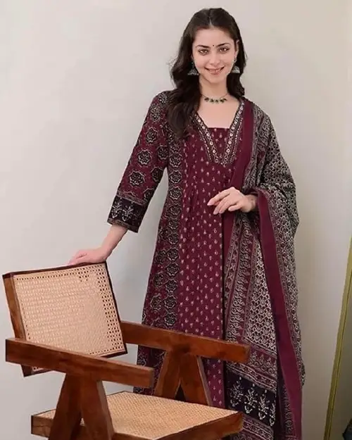 A woman posing with a maroon printed long ethnic dress and matching dupatta.
