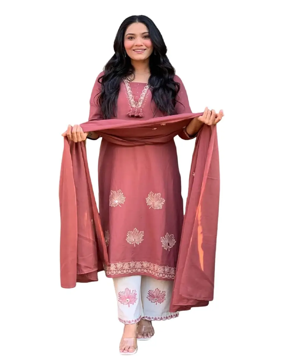 A woman wearing a peach-colored georgette Anarkali-style kurta with detailed embroidery, paired with matching pants and a dupatta.