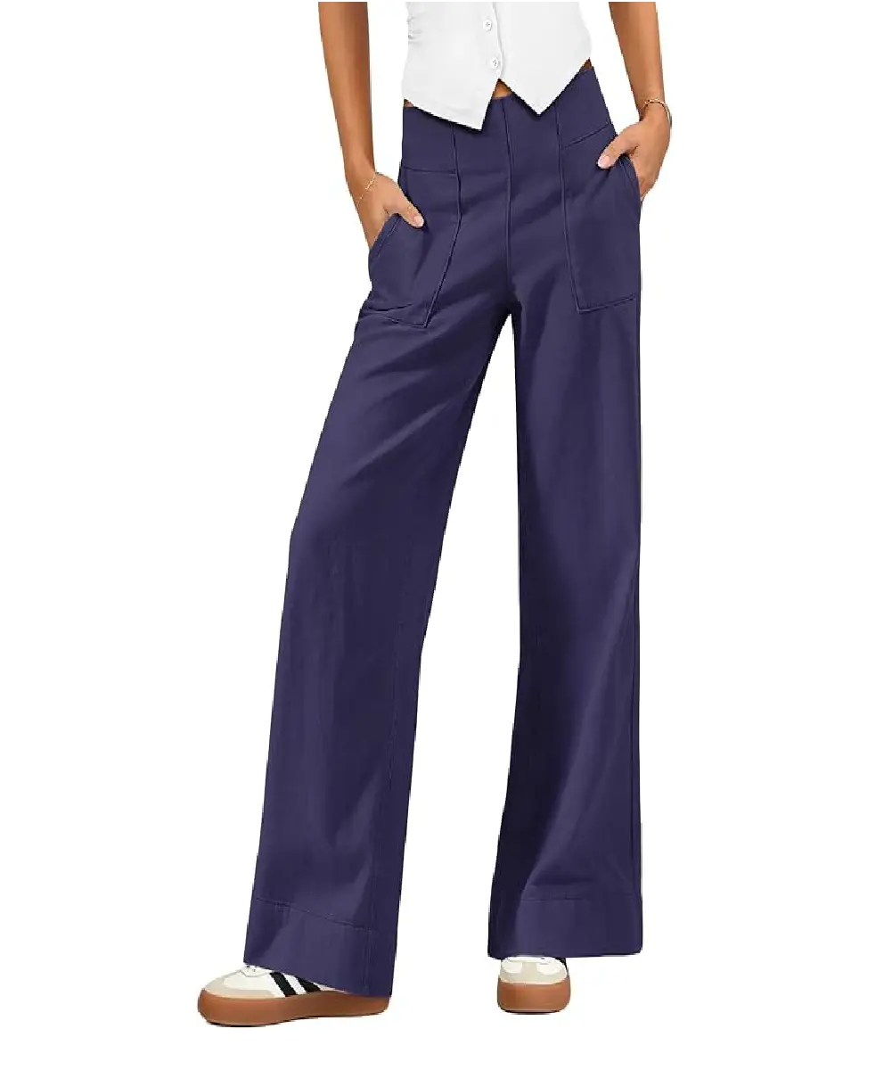 A woman wearing navy blue wide-leg chino pants with seamed detailing, oversized pockets, and an elastic waistband, styled with a white top and sneakers.