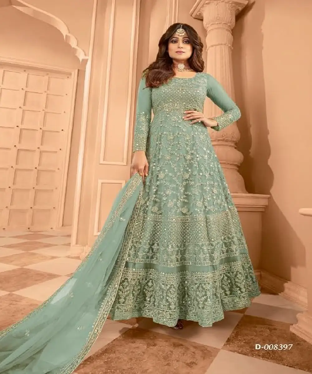 A woman is wearing a beautiful mint green net anarkali suit, which has heavy sequence coding embroidery work.