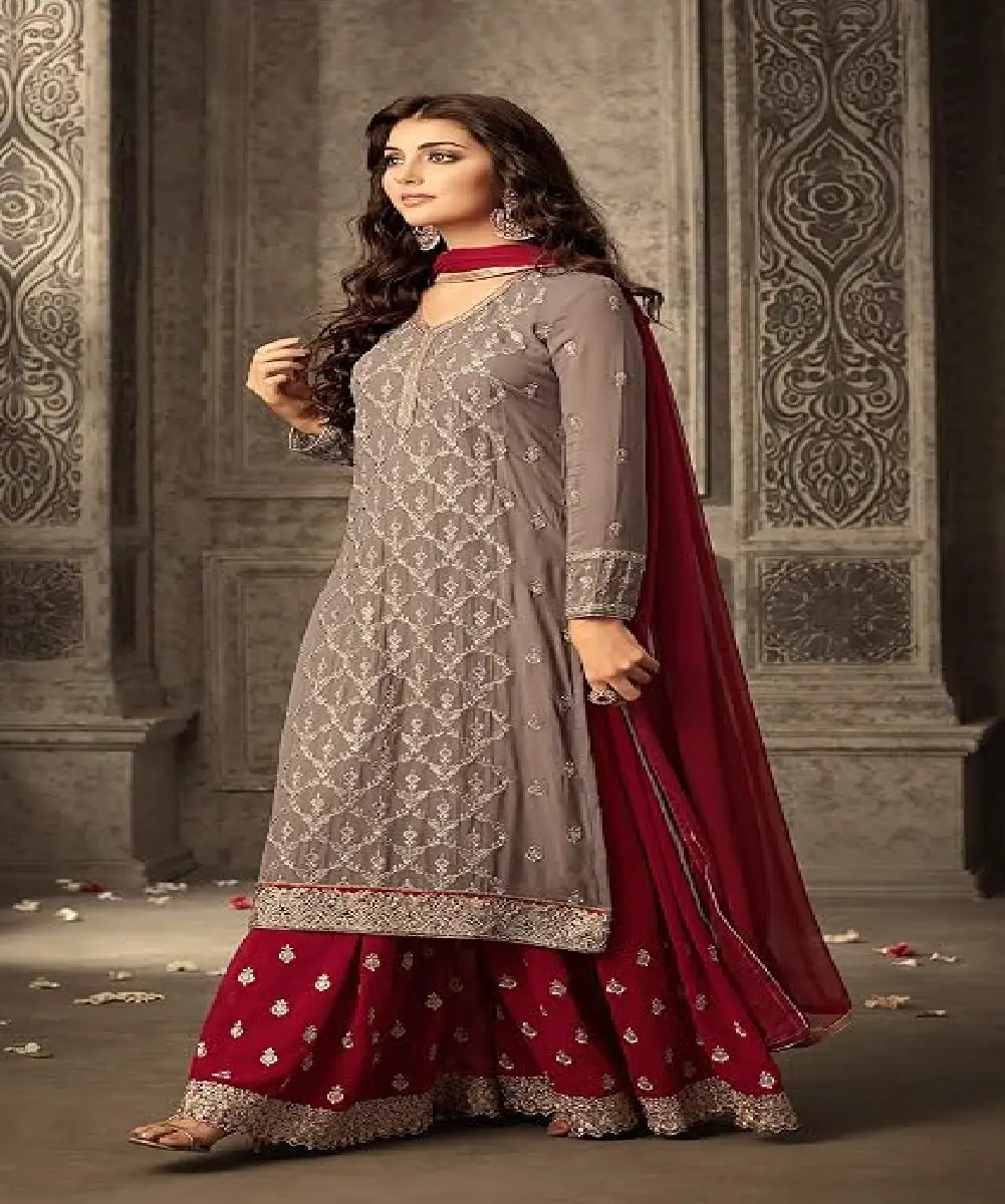 A woman is wearing a gray embroidered kurta, dark maroon palazzo pants, and a matching dupatta.
