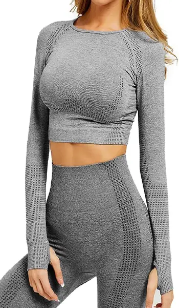 A woman modeling a grey seamless long sleeve crop top with a dotted contouring pattern and thumbholes on the cuffs.