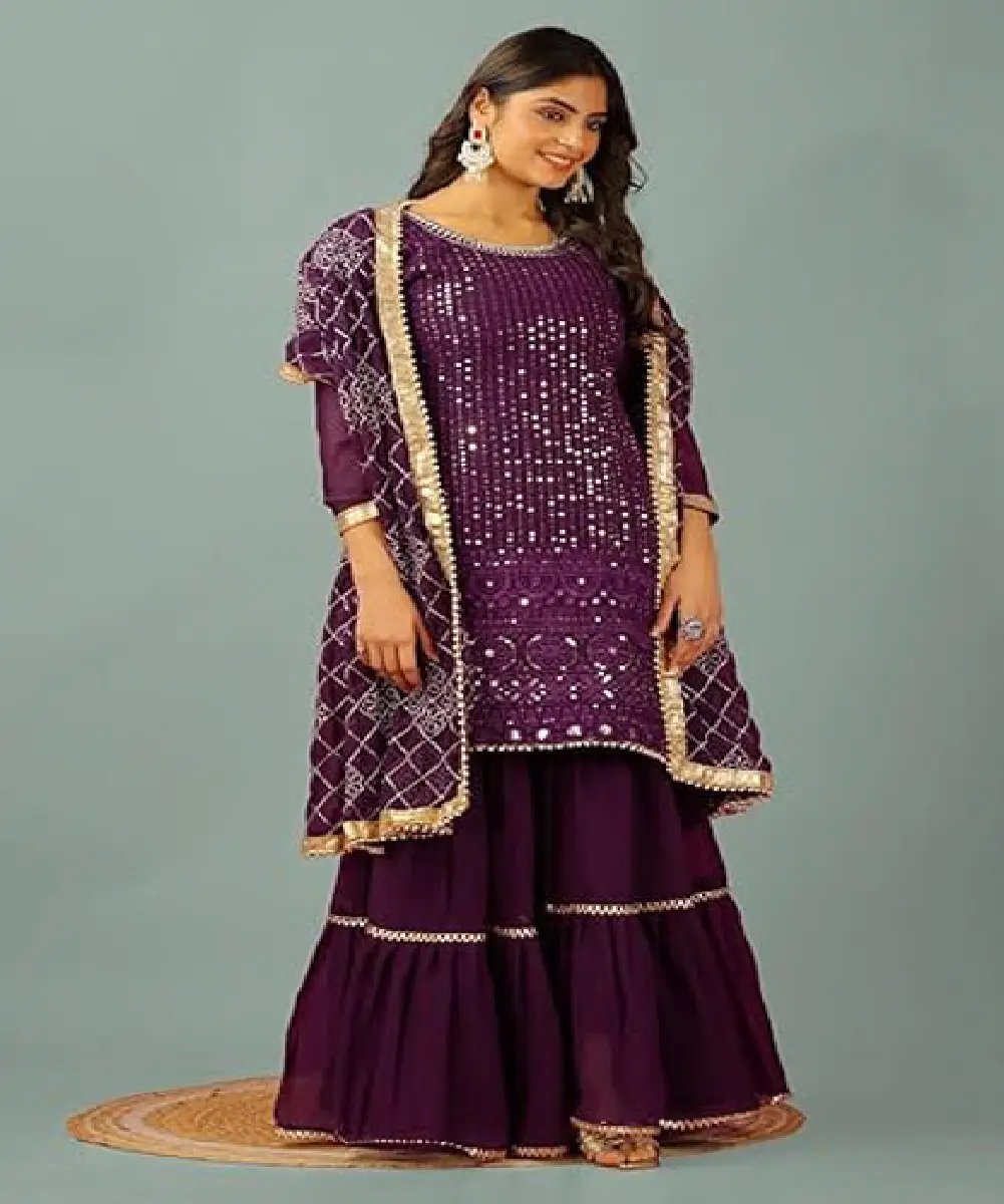 A woman wearing a purple ready-to-wear kurti and sharara set, paired with a matching dupatta, featuring double interlocking stitching.