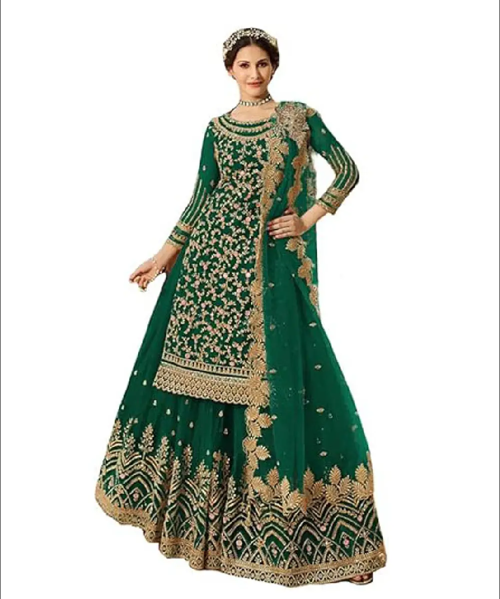 A woman wearing a green sharara-style suit featuring heavy embroidered floral patterns on the yoke, sleeves, and bottom, paired with a matching embroidered dupatta.