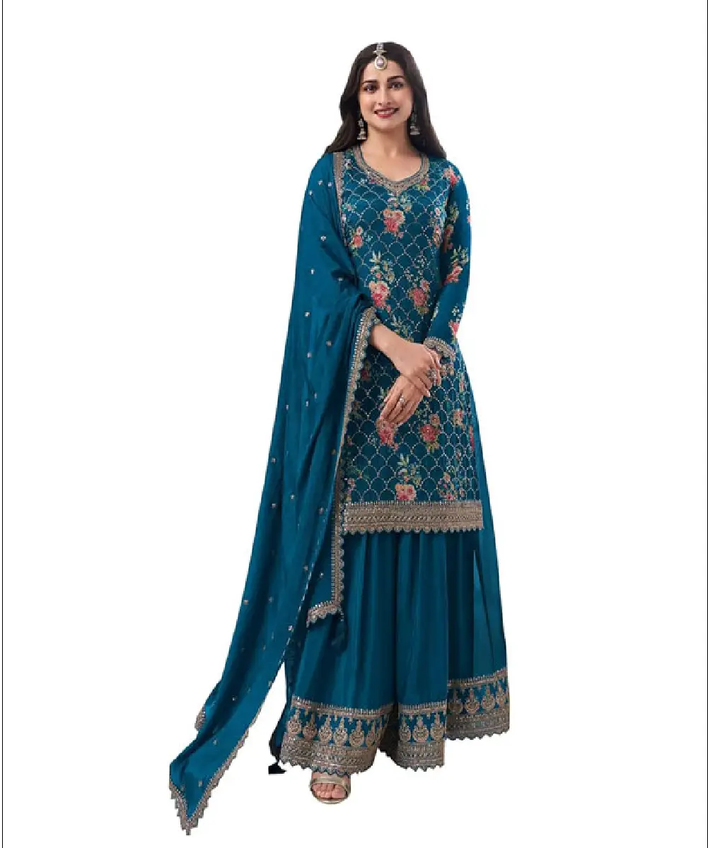 A woman wearing a teal, ready-to-wear Anarkali salwar kameez lengha suit featuring heavy floral embroidery and sequence work, paired with a matching dupatta.
