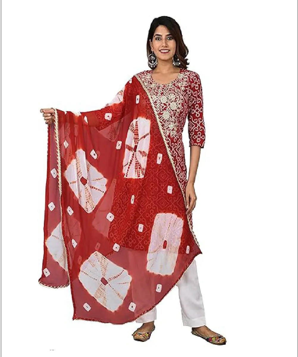 A woman wearing a straight-cut red cotton kurti with a round neck and 3/4 sleeves, paired with white rayon pants and a decorative red and white tie-die chiffon dupatta.