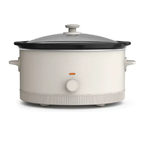 Front view of an off-white Bella 6-quart slow cooker featuring a glass lid, cool-touch handles, and a manual temperature control dial.