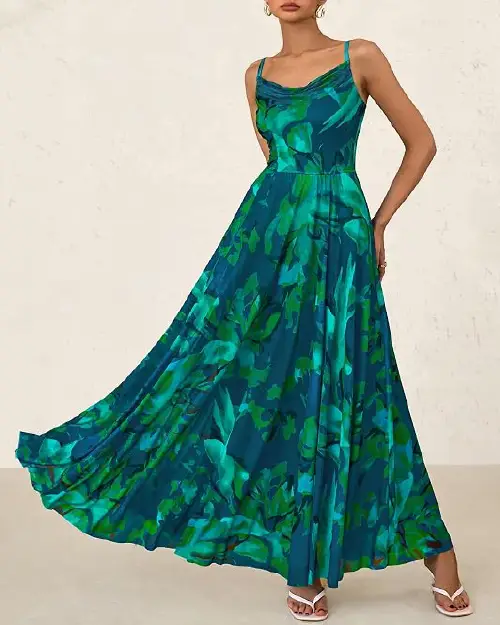 Woman wearing a teal and green abstract watercolor floral print sleeveless maxi dress with a cowl neckline.