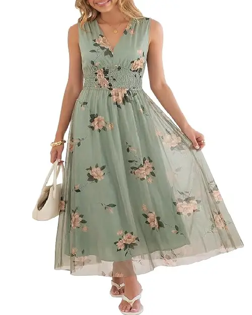 Woman wearing a sage green sleeveless midi dress featuring a V-neckline, smocked waist, and pink floral embroidery/mesh overlay.