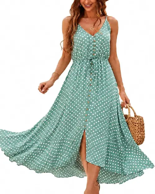 Woman wearing a sage green polka dot sleeveless maxi dress with a front button-down design and side slit.