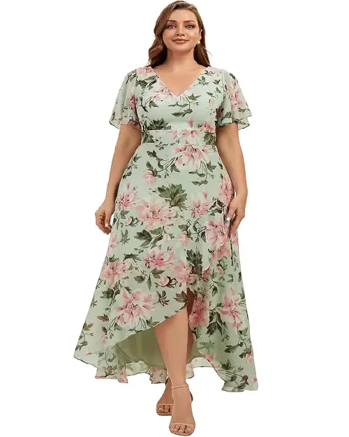 Plus size woman wearing a mint green high-low maxi dress with pink floral prints and flutter sleeves.
