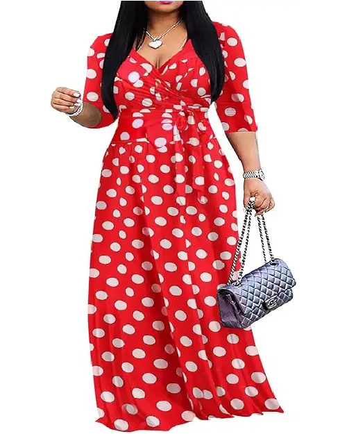 Woman wearing a red and white polka dot V-neck wrap maxi dress with three-quarter sleeves and a tied waist, holding a quilted bag.