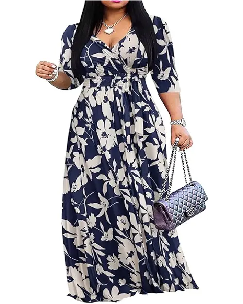 Woman wearing a navy blue and cream large floral print wrap maxi dress with three-quarter sleeves and a tied waist.