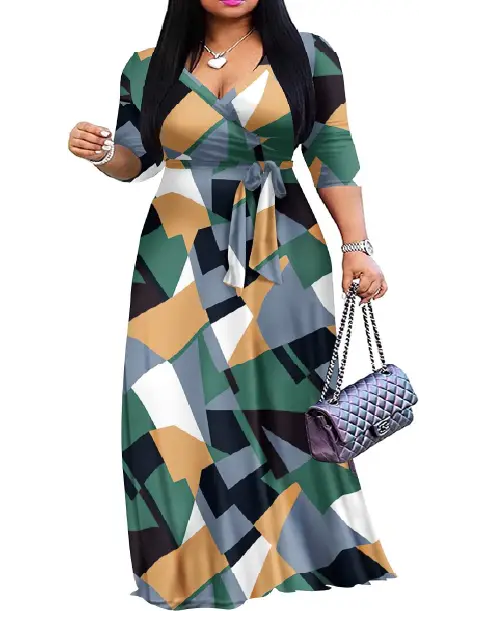 Woman wearing an abstract geometric color-block wrap maxi dress in shades of green, beige, black, and white, featuring a waist tie.
