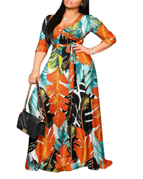 Woman wearing a tropical botanical leaf print wrap maxi dress featuring vibrant orange, teal, and black palm fronds, with a waist tie.
