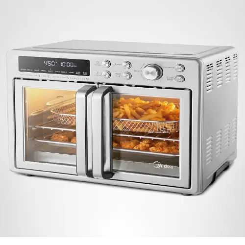 Midea stainless steel double-door air fryer oven with a digital LED display screen and dial controls on the right, showing french fries and chicken nuggets inside through the glass doors.