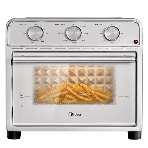 Midea stainless steel toaster oven with three top-mounted mechanical control dials and a glass door showing a basket of golden-brown french fries inside.