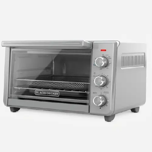Silver and gray Black+Decker air fryer toaster oven with three analog control dials on the right side and a glass pull-down door showing an internal wire air fry basket.