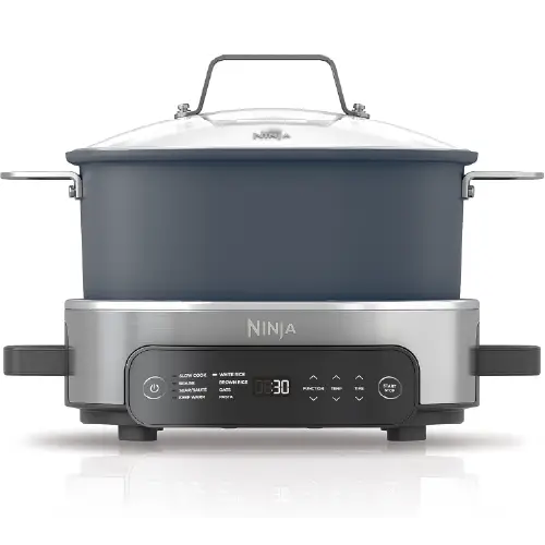 Slow cooker liners box next to a stainless steel slow cooker with stew