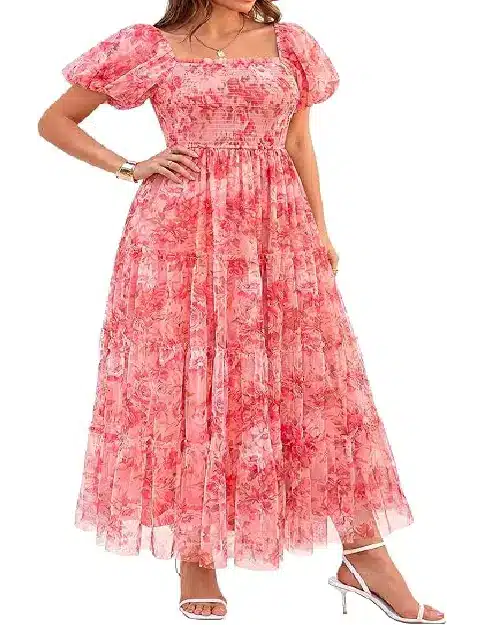 Model in a coral pink floral mesh maxi dress with puff sleeves, a smocked bodice, and a tiered flared skirt overlay.
