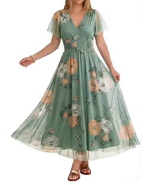 Model in a light sage green mesh maxi dress featuring peach-toned florals, sheer flutter sleeves, and a smocked elastic waist.