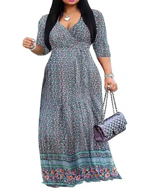 Model wearing a teal blue maxi dress with an allover ditsy floral print, three-quarter sleeves, V-neckline, and border printed hemline, holding a black quilted handbag.