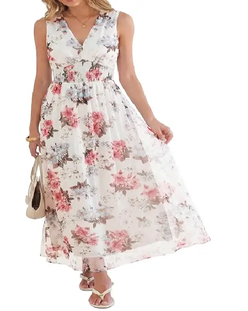 Woman wearing a white sleeveless maxi dress decorated with pink floral print and a fitted smocked waist.