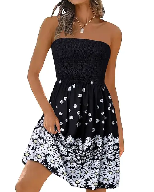Model in a black strapless smocked sundress covered in scattered white daisies with a dense floral hemline.