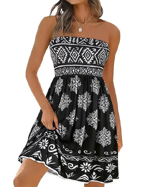 Woman wearing a black strapless mini dress decorated with white tribal geometric patterns across the smocked bodice and skirt hem.