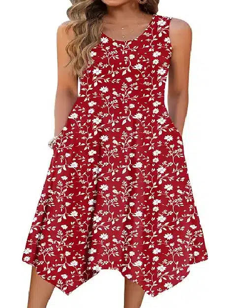 Woman wearing a sleeveless crimson red midi dress with a white floral print, featuring a scoop neck and asymmetrical handkerchief hem.
