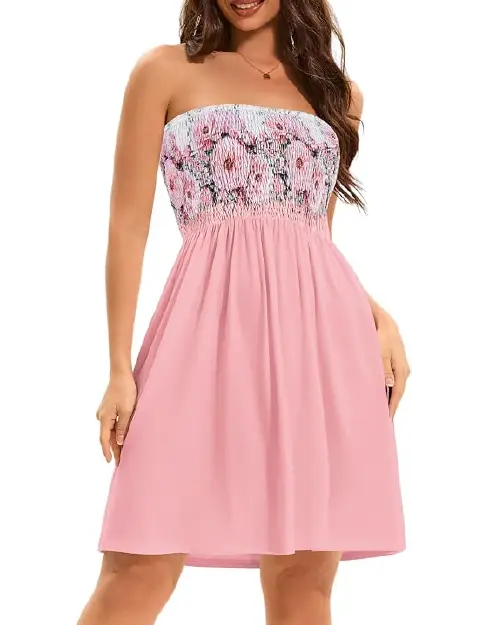 Woman wearing a light pink strapless mini dress with a white and rose floral smocked bust and a soft flared skirt.