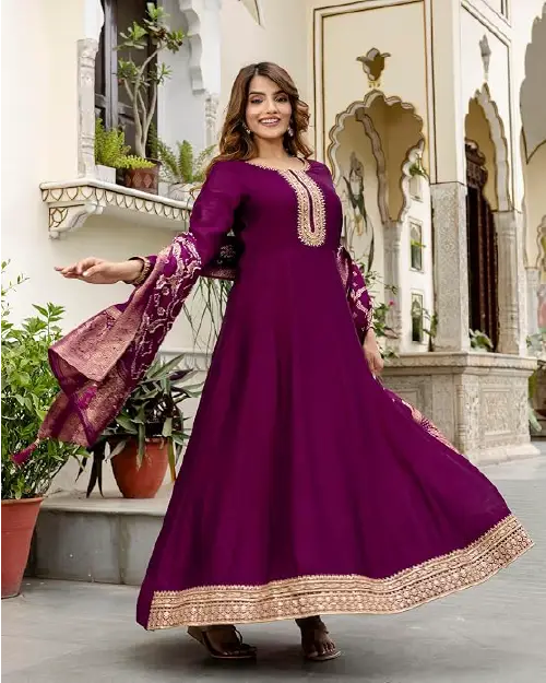 Rich purple Anarkali suit with gold border embellishments and a traditional Bandhani dupatta.