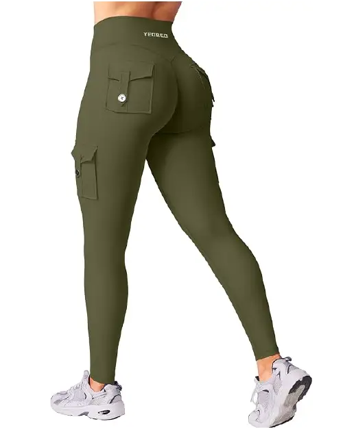 Olive green high-waisted active cargo leggings for women with buttoned utility pockets on the legs and back, paired with grey athletic shoes.